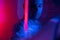 Close-up cinematic portrait of handsome young man in neon blue pink lighted room, stylish male model indoors. Reflection