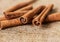 Close up cinnamon sticks and coffee on hessian canvas with wooden background