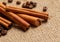 Close up cinnamon sticks and coffee on hessian canvas with wooden background