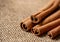 Close up cinnamon sticks and coffee on hessian canvas with wooden background