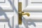 Close up of classic golden door handle on white door