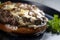 Close-up of a classic hamburger steak with melted blue cheese and sauteed mushrooms on a toasted bun