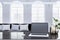 Close up of clean designer office workplace with empty mock up laptop screen and other items. Blurry office interior background.