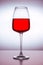 A close-up of a clean glass filled with red wine on the white background. Plain surface, no splashes. Restaurant glassware, serve