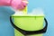 Close-up of cleaner woman hand squeezing cloth in bucket filled with soap