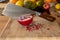 Close-up of a cleaver stuck in a pomegranate on a wooden cutting board