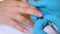 Close-up of the clientâ€™s hand and the nail master in processing nails in gloves will raise a cuticle before removal. nail care