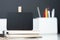 Close up clip blackboard on notebook with blur modern pencil box on table and dark grey wall in office desk,mock up space for
