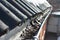 A close-up of a clogged rain gutter of an asbestos roof with water, leaves, and dirt. Cleaning a dirty and clogged roof gutter to