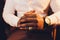 Close up or closeup of hands of faithful mature man praying. Hands folded, interlaced fingers in worship to god. Concept for