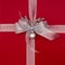 Close-up closeup of red Christmas gift present with metalllic silver ribbon, bow and decorations. Beautiful, fancy, elegant