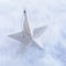 Close-up closeup of simple, modern, silver glitter star Christmas ornament decoration on white background