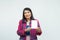 Close up cnfident middle-aged Asian woman wearing pink casual wear holding and pointing a white box on her hand on white