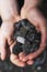 A close up coal rocks being held in a hand