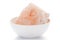 Close-up of coarse Himalayan Pink Salt sodium chloride edible on white ceramic bowl.