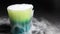 Close up cocktail drink in green glass with dry ice