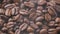 Close-up coffee beans with smoke are roasted and rotated