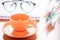 Close up of coffee cup with book and eyeglasses