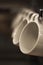 Close up Coffee cup hanging on a shelf with dark brown blurred background