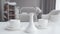 Close-up of coffee cups and vase standing on the table in sunlight as blurred maid wiping dust from bed at the