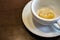 Close up. Coffee stains on the bottom of a white cup with saucer on the wooden table