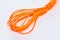 Close-up on a coil of orange nylon cord on white background