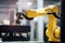 close-up of collaborative robot arm, with view of factory floor visible in the background