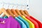 Close up collection of colorful rainbow t-shirts hanging on wooden clothes hanger