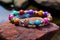 a close-up of a colorful beaded bracelet on a textured granite rock