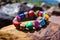 a close-up of a colorful beaded bracelet on a textured granite rock