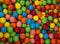 Close up of colorful candies texture background. Rainbow colorful candy coated chocolate pieces in a bowl
