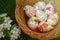 Close up of colorful decorted hand painted Easter eggs in a basket on grass with cherry bossom