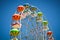 Close-up of colorful ferris wheel on vivid blue sky