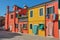 Close-up of colorful houses and doors with cloth on a sunny day in Burano.