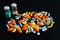 Close up of colorful pile of medicine pills on black background. Healthcare, overdose or treatment concept