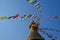 CLOSE UP: Colorful prayer flags flutter in winds blowing over the top of a stupa
