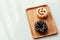 Close up of colorful and sweet donuts and one smiley face donut near windows.