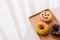 Close up of colorful and sweet donuts and one smiley face donut near windows.