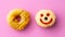 Close up of colorful and sweet donuts with one smiley face on pink background.