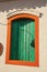 Close-up of colorful wooden window with closed green blinds in Paraty.