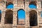 Close up of Colosseum wall with arch windows and blue sky
