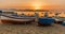 A close up of colourful fishing boats at Aspra Sicily as the sun sets over the Gulf of Palermo