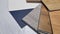 close up combination of interior material samples board contains ash and oak wooden vinyl flooring tiles, blue and grey fabric