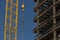 Close up of commercial office building under construction with construction worker ,crane, steel beams with weight of steel beams