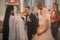 The close-up composition of the priest holding the golden crown while the groom is kissing it during the wedding