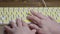 Close-up of a computer keyboard with braille. A blind girl is typing words on the buttons with her hands. Technological