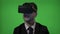 Close up of a computer programmer man dressed in suit coding on vr augmented reality glasses on green screen -