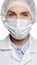 Close-up of concentrated woman doctor in surgical mask is looking at camera. Operation, medical practitioner, surgery