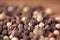 Close up of condiment on brown wooden background. Bunch of different peppers on table with space for your text.