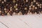 Close up of condiment on white wooden background. Bunch of different peppers on table with space for your text.